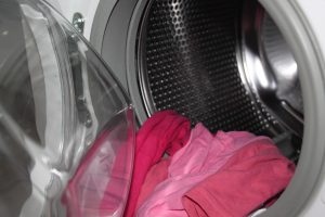 broken washing machine with laundry spilling out